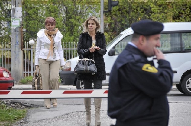 Cựu Á hậu (tóc vàng, trang phục đen) đang bị áp giải về quê nhà xét xử.