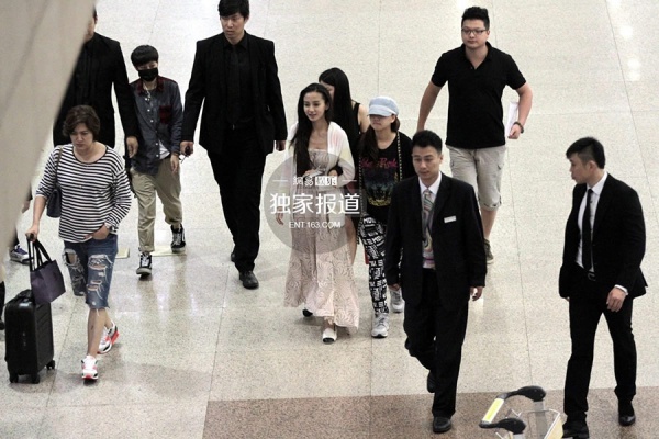 Angela Baby đi giày bệt, mặc váy rộng, liên tục đưa tay chặn trước bụng, được trợ lý dìu khi có mặt tại sân bay.