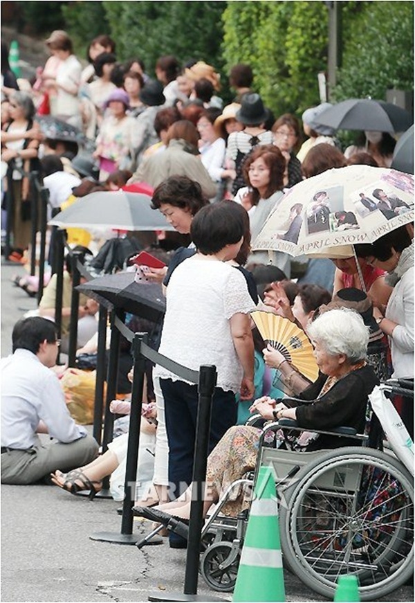 Hàng nghìn người xếp hàng bên ngoài biệt thự của Bae Yong Joon. Trong đó, có cả cụ bà phải ngồi xe lăn.