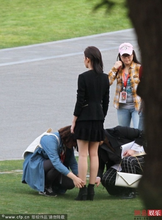 Cô để mặc trợ lý cúi xuống chỉnh giày.