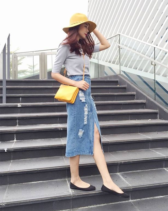 Với Thanh Hằng, cô chọn kết hợp chân váy denim xẻ mix cùng áo thun màu tro đơn giản. Mũ fedora và túi xách được cô khéo chọn cùng tông màu vàng mù tạt khá thời trang.