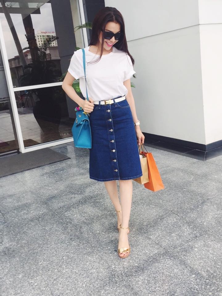 Chân váy denim dáng dài qua đầu gối, thiết kế hàng khuy chạy dọc thân váy được Trà Ngọc Hằng mix cùng áo phông trắng đơn giản.
