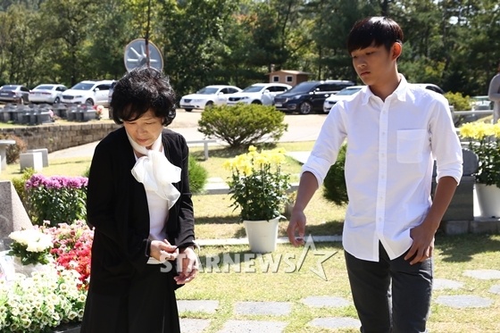 Hwan Hee đứng lặng người bên bà trước mộ mẹ.