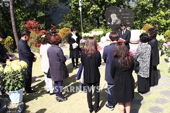 Tất cả lặng người bên khu mộ. Họ chăm chú đọc Kinh cầu nguyện và đặt hoa tưởng niệm.