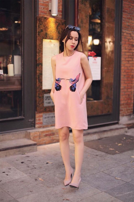 Để váy liền thân đơn sắc có điểm nhấn và ngọt ngào hơn thì phần  họa tiết nhỏ xinh điểm bông hoa hồng phần chân váy như  Linh Nga là sự lựa chọn khá thú vị.