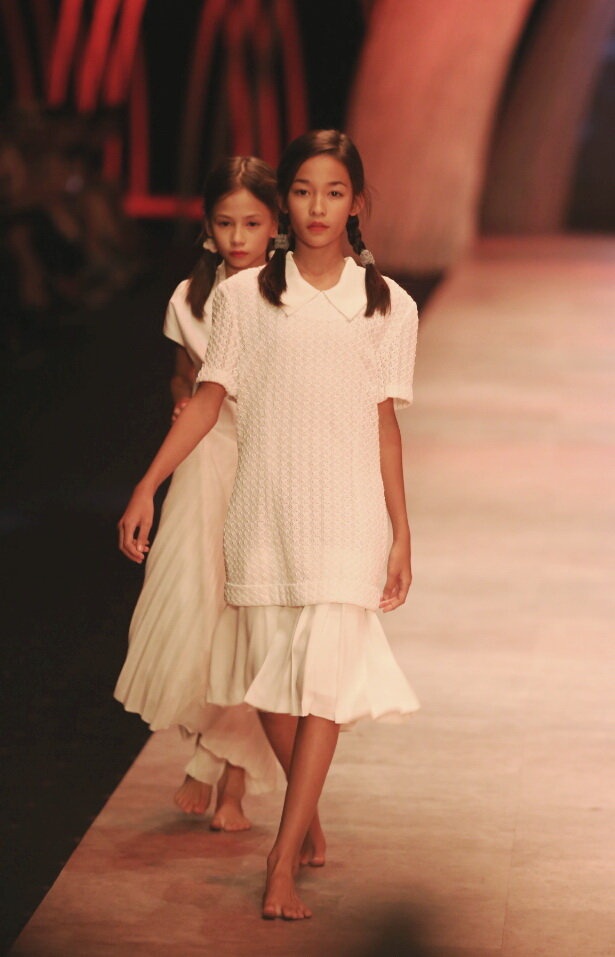 Hai mẫu nhí trình diễn trong sô của nhà thiết kế Li Lam vào tối 16-10 tại Tuần lễ thời trang quốc tế Việt Nam 2015 - Ảnh: Gia Tiến
