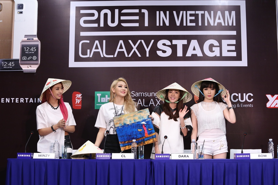 Khi nhận được món quà đặc biệt là những chiếc nón lá xinh xắn, bên trên có thêu phong cảnh đẹp của Việt Nam trong họp báo đêm nhạc 2NE1 Galaxy Concert in Vietnam 2014 diễn ra vào tối 10/8, 2NE1 đã bày tỏ sự thích thú và hào hứng. Thậm chí, cả 4 thành viên còn ngắm nghía rất kỹ những hình ảnh được thêu trên nón lá.