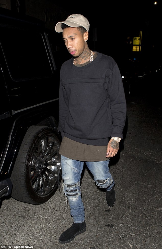 Rapper Tyga mặc trang phục bụi phủi, tối màu đồng điệu với cô bạn gái bốc lửa. Tyga tên thật là Michael Ray Nguyen-Stevenson, 25 tuổi mang dòng máu gốc Việt. Rapper cặp kè với kiều nữ nhà Kardashian – Jenner gần 2 năm nay và thường xuyên có mặt trong các sự kiện, chuyến đi của gia đình nổi tiếng này. 