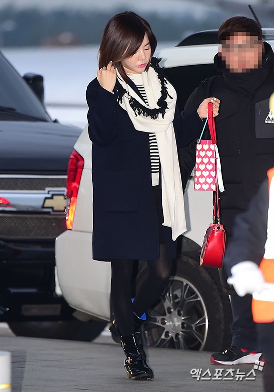 Sunny nhỏ nhắn trong áo khoác dạ xanh đen phối cùng chân váy và áo kẻ, điểm nhấn là túi đeo chéo màu đỏ. 