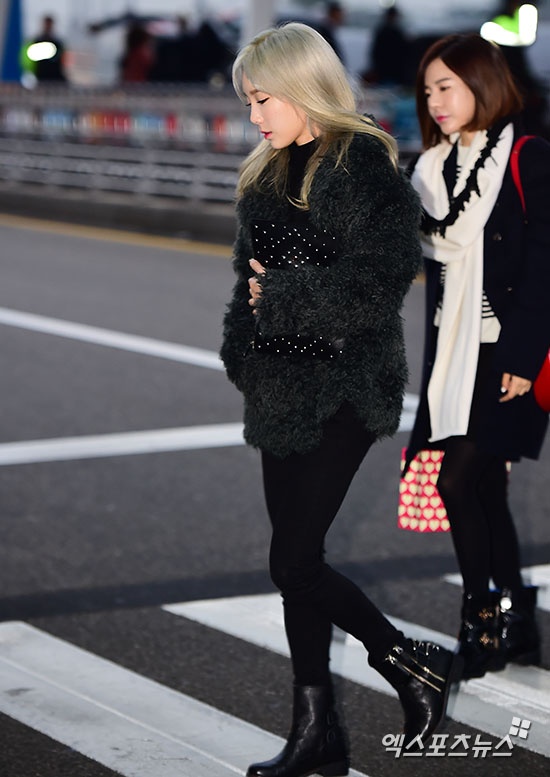 Trưởng nhóm Taeyeon xúng xính trong trang phục “cây đen” gồm áo choàng lông và skinny jeans. 