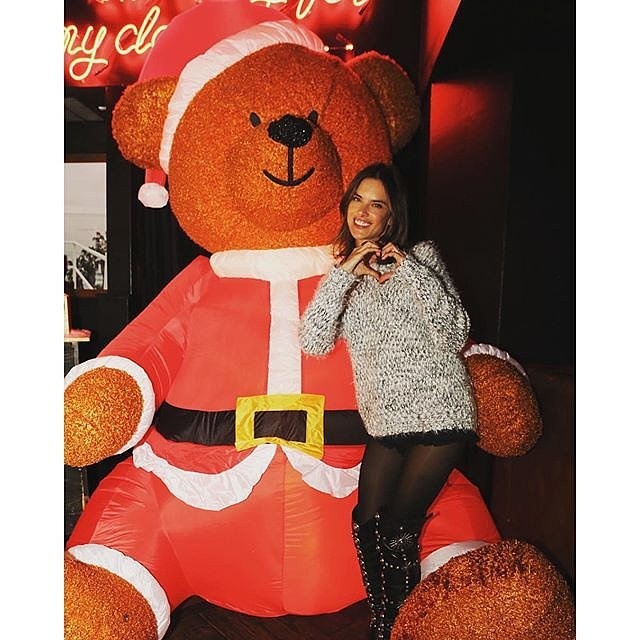 Chân dài Alessandra Ambrosio chụp ảnh ngộ nghĩnh bên chú gấu mặc bộ đồ ông già Noel cỡ lớn.