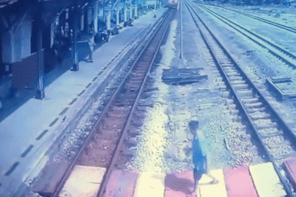 Bang qua duong ray khi tau lao toi, nguoi phu nu suyt gap nguy hiem hinh anh