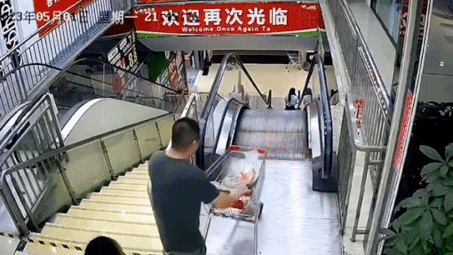 Nguoi dan ong tha xe day roi tu do tren thang cuon hinh anh