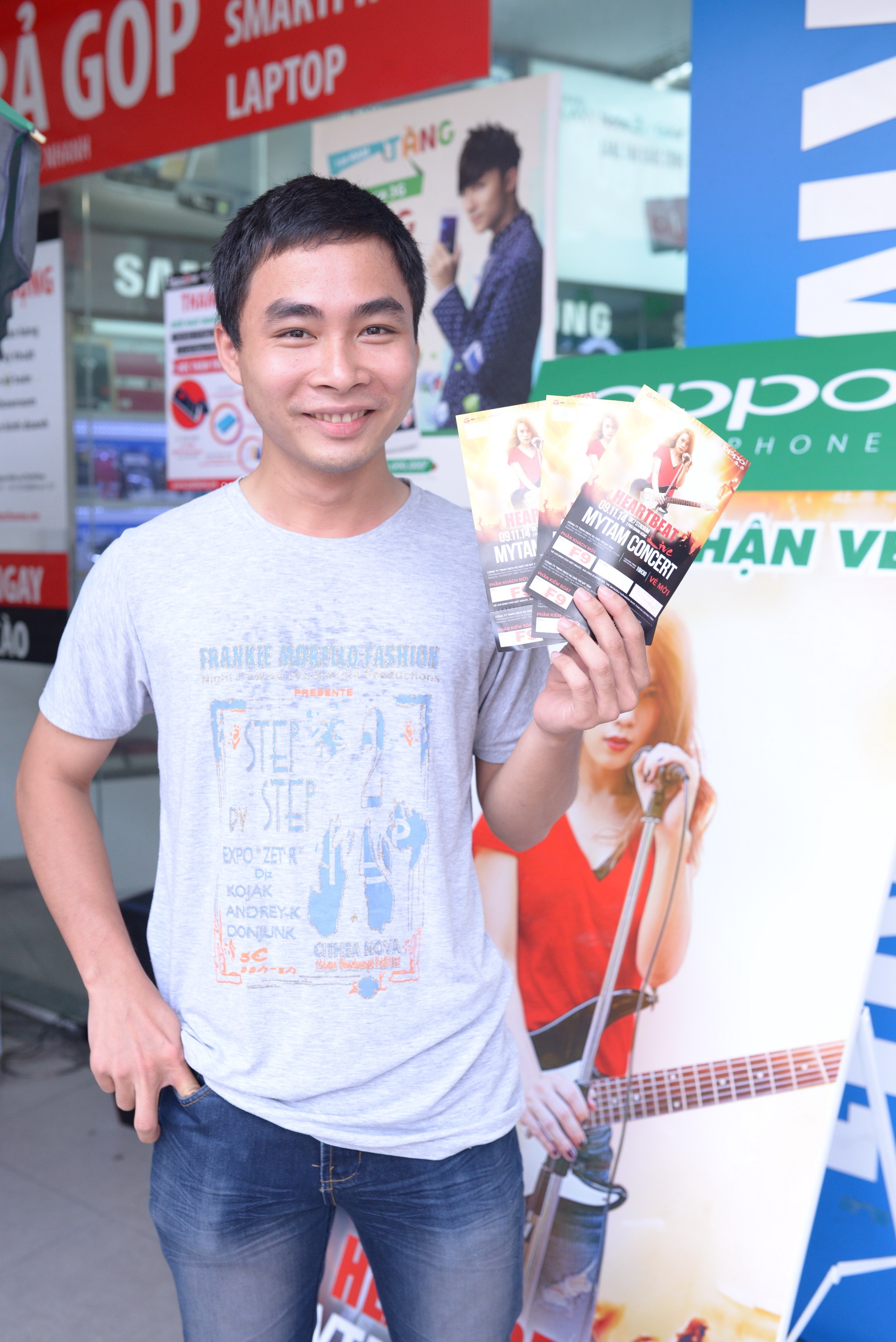 Một người hâm mộ khoe chiếc vé vừa được nhận tại điểm phân phát.