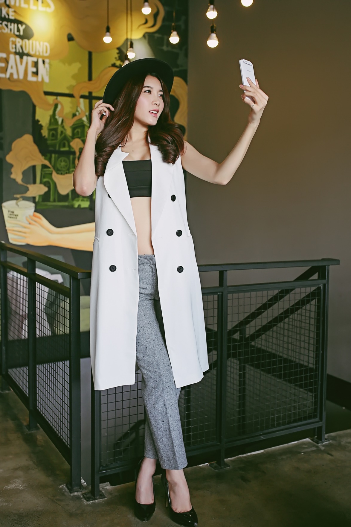 Áo măng-tô màu trắng khoác ngoài cùng quần ống đứng và áo ống màu đen vừa tôn vóc dáng, vừa giữ ấm cho bạn gái khi thời tiết chớm thu.