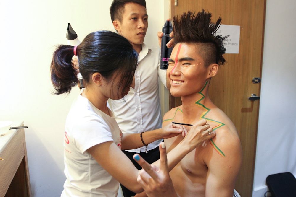 Quang Hùng được chuyên gia trang điểm tạo nhiều đường nét màu sắc trên gươnng mặt và cơ thể. Phần tóc của thí sinh này được chuyên gia tạo kiểu dựng đứng, sau đó dùng xịt giữ nếp của TRESemmé định hình trong suốt buổi làm việc, giúp anh tạo nét hoang dại và mạnh mẽ.