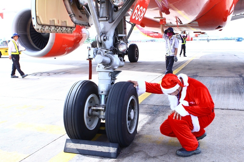 Kỹ thuật viên trong trang phục ông già Noel miệt mài làm việc ngoài sân bay để đảm bảo những chuyến bay an toàn cho hành khách.