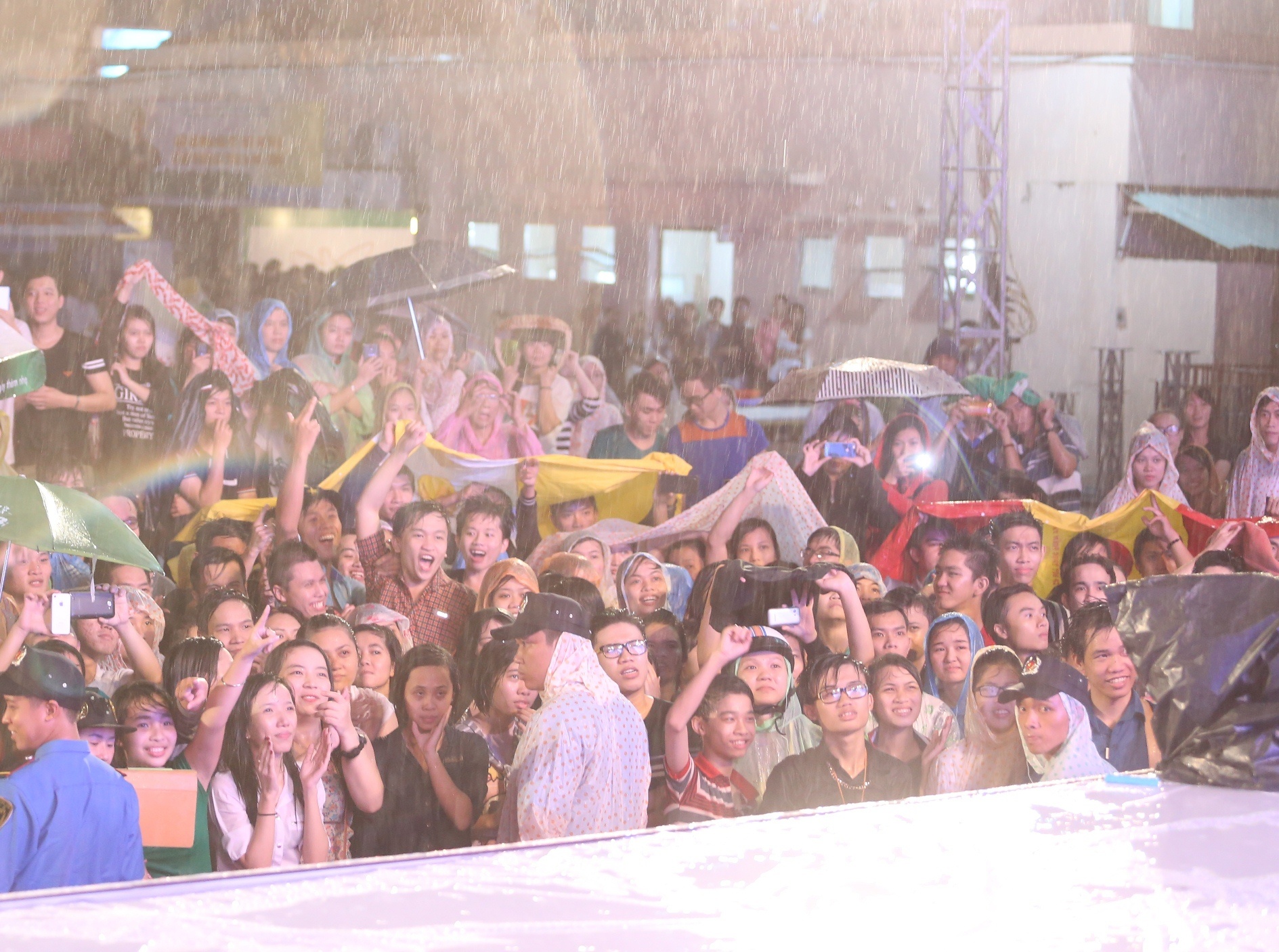  Ở bên dưới, các khán giả trẻ cổ vũ hết mình. Họ tận dụng áo mưa, áo khoác, ô hay bất kì dụng cụ nào có thể dùng để che chắn. Minh Hằng chia sẻ chính sự nhiệt tình của khán giả đã giúp cô quên đi thời tiết xấu. 
