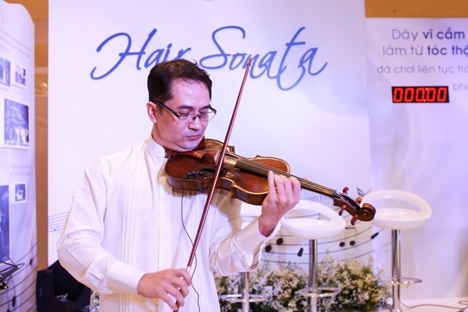 Nghệ sĩ Xuân Huy biểu diễn với cây vĩ cầm độc đáo có dây vĩ làm từ tóc của các cô gái Việt sau 2 tuần chăm sóc với bộ sản phẩm Dove ngăn rụng róc.