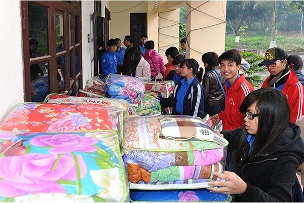 Thanh niên tình nguyện Đại học Kinh tế Quốc dân phân phát chăn cho các đối tượng chính sách.