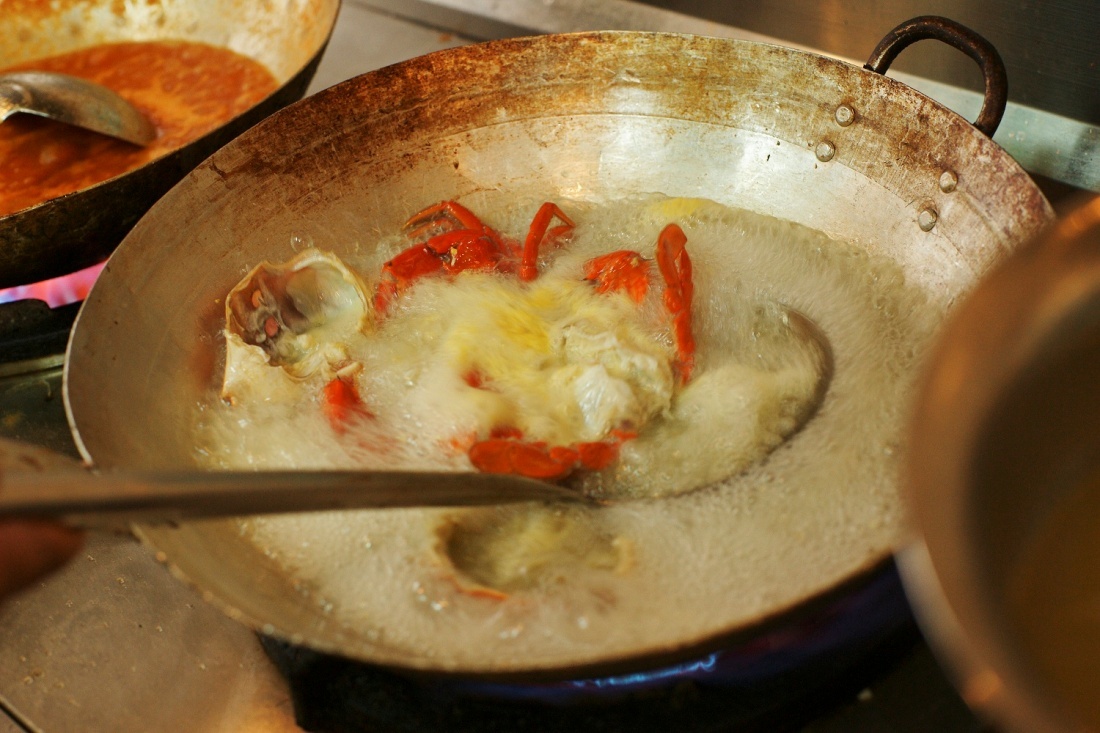 Cua được sơ chế rồi chiên vàng trong chảo ngập dầu.