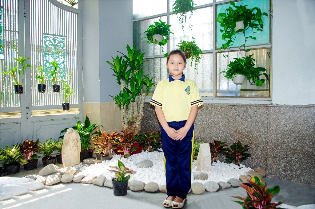 Bé Đào Nguyễn Thanh Trúc bên mảng xanh tại nhà