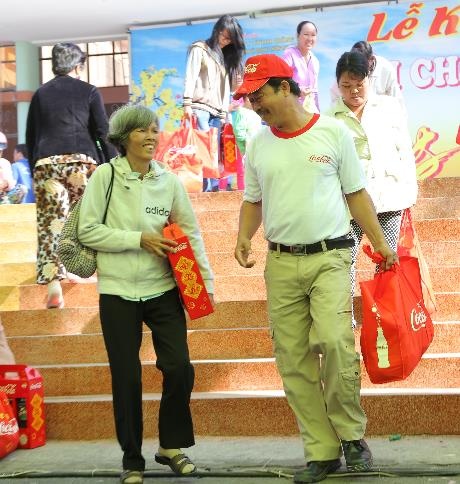 Tình nguyện viên Coca-Cola giúp người dân mang quà Tết ra xe buýt tại Nhà thiếu nhi quận Thủ Đức, TP HCM trong sáng ngày 31/1