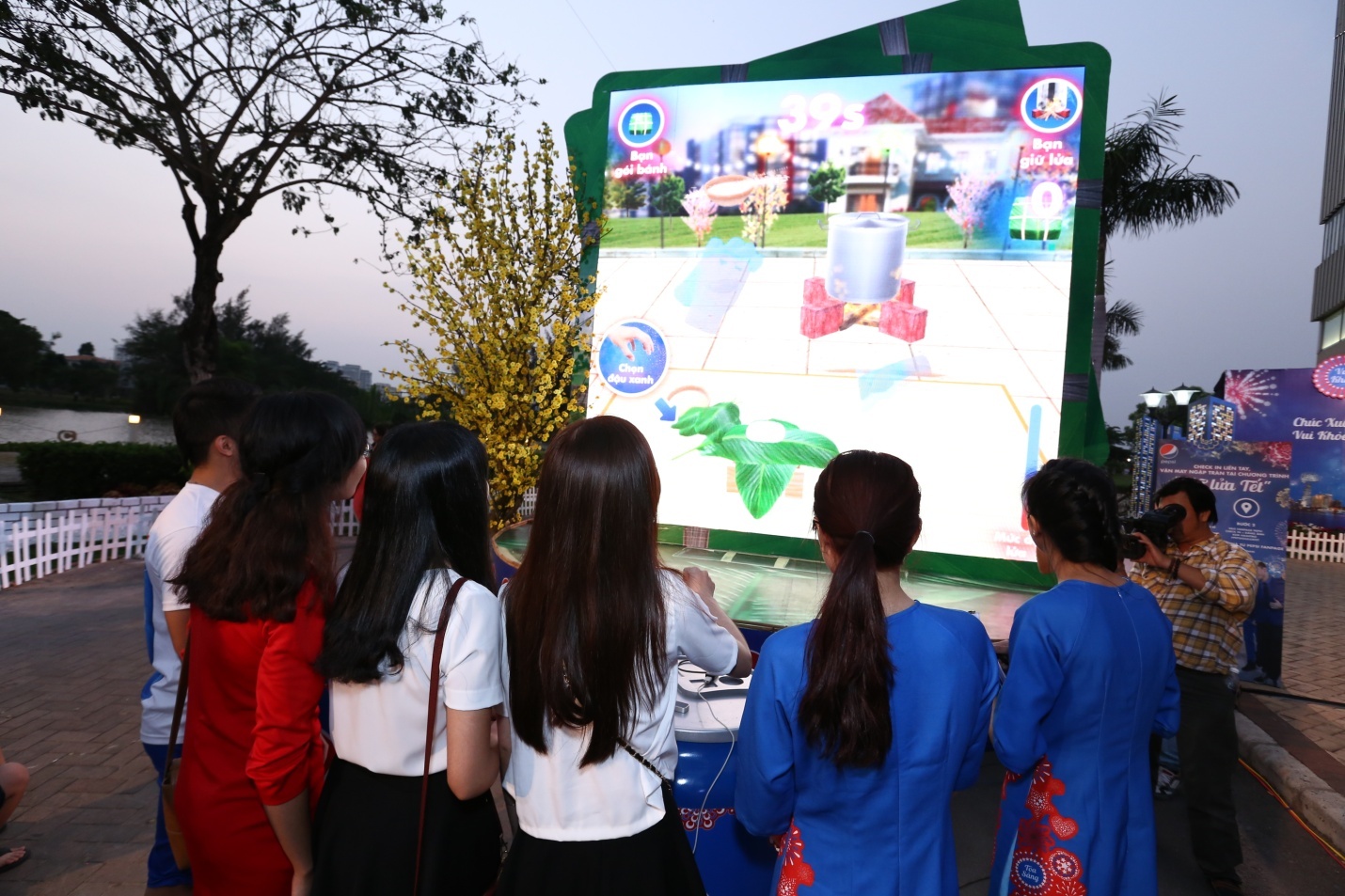 Chăm chú nghe hướng dẫn gói bánh trên màn hình.