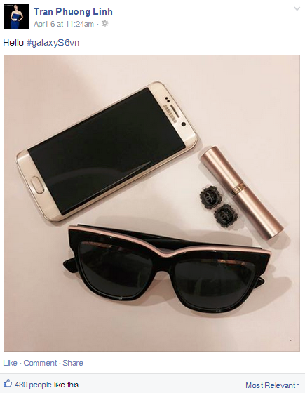    Phương Linh  khoe kính mát đen viền, thỏi son vàng ánh kim, hoa tai Chanel và Galaxy S6 edge trắng ngọc trai.