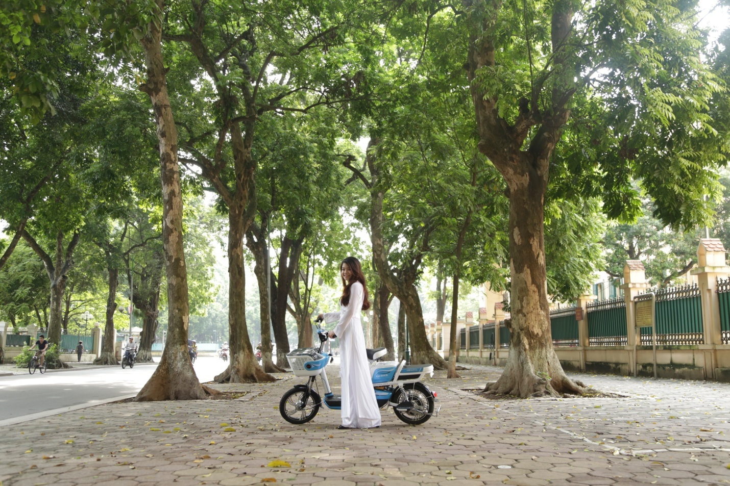 Nữ sinh duyên dáng, thướt tha trong tà áo dài trắng bên xế điện.