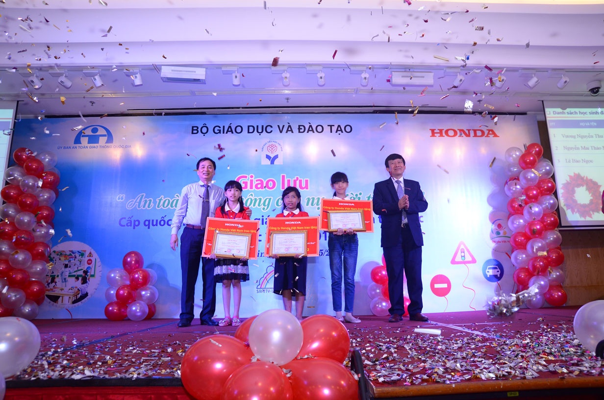 Ông Phạm Ngọc Đinh - Vụ trưởng Vụ Giáo dục Tiểu học, Bộ Giáo dục và Đào tạo cùng ông Hồ Mạnh Tuấn - Phó tổng giám đốc Honda Việt Nam trao giải nhất cho các em học sinh.