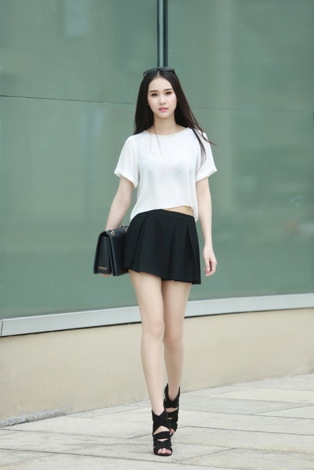 Gợi ý cho bạn set đồ đơn giản nhưng không bao giờ lỗi mốt: áo thun trắng mix váy ngắn xếp ly, đi cùng boots cột dây.