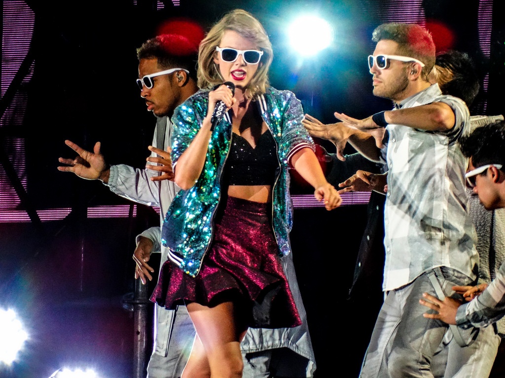 Ngay sau đó, cô công chúa ấy lột xác trở thành một ngôi sao nhạc pop trẻ trung. Giọng ca Shake it off chọn bộ cánh bắt sáng nổi bật: crop-top đen, váy ngắn màu đỏ cá tính, áo khoát ánh kim và đeo thêm đôi kính đen gọng trắng nghịch ngợm.