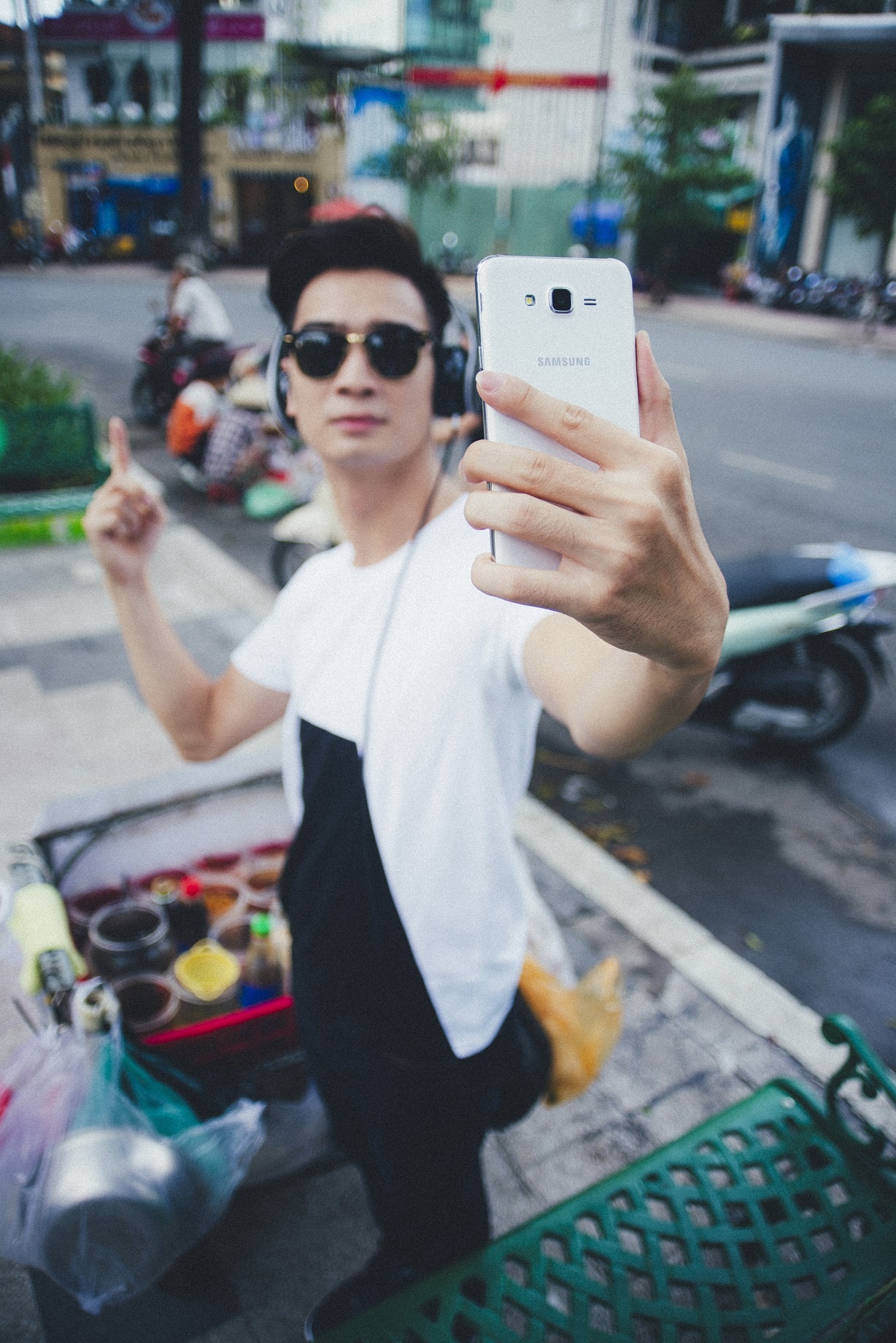 Diện trang phục đen-trắng, đeo kính râm và tai nghe, Slim V thoải mái selfie giữa phố Sài Gòn.