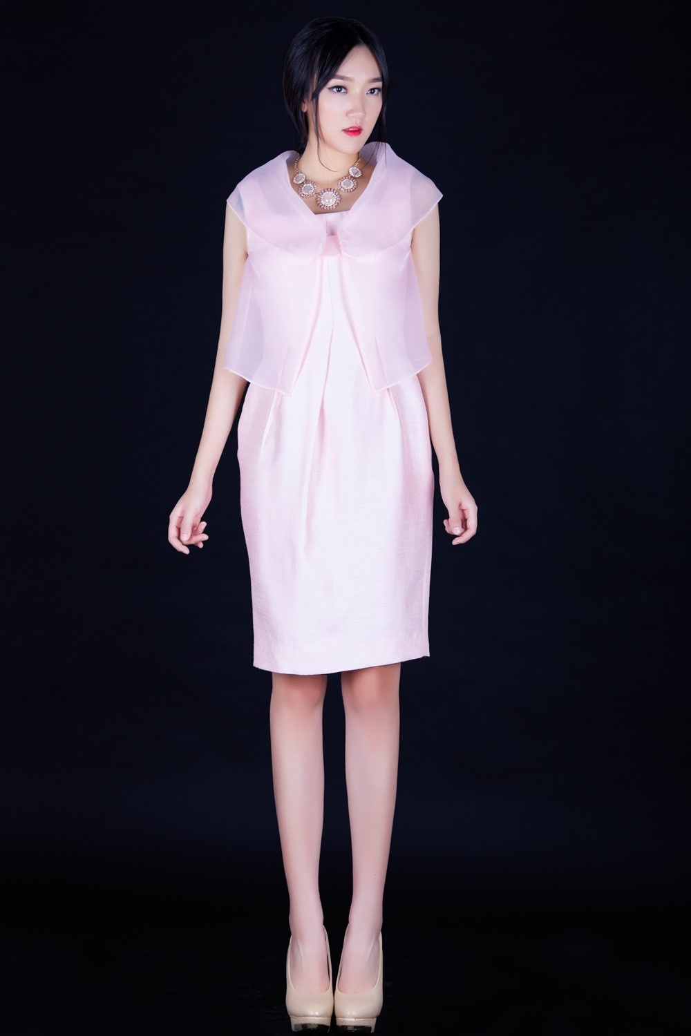 Chỉ cần cách điệu thêm một tấm voan mỏng giả áo khoác, chiếc đầm màu hồng đơn giản trở nên thu hút hơn.  