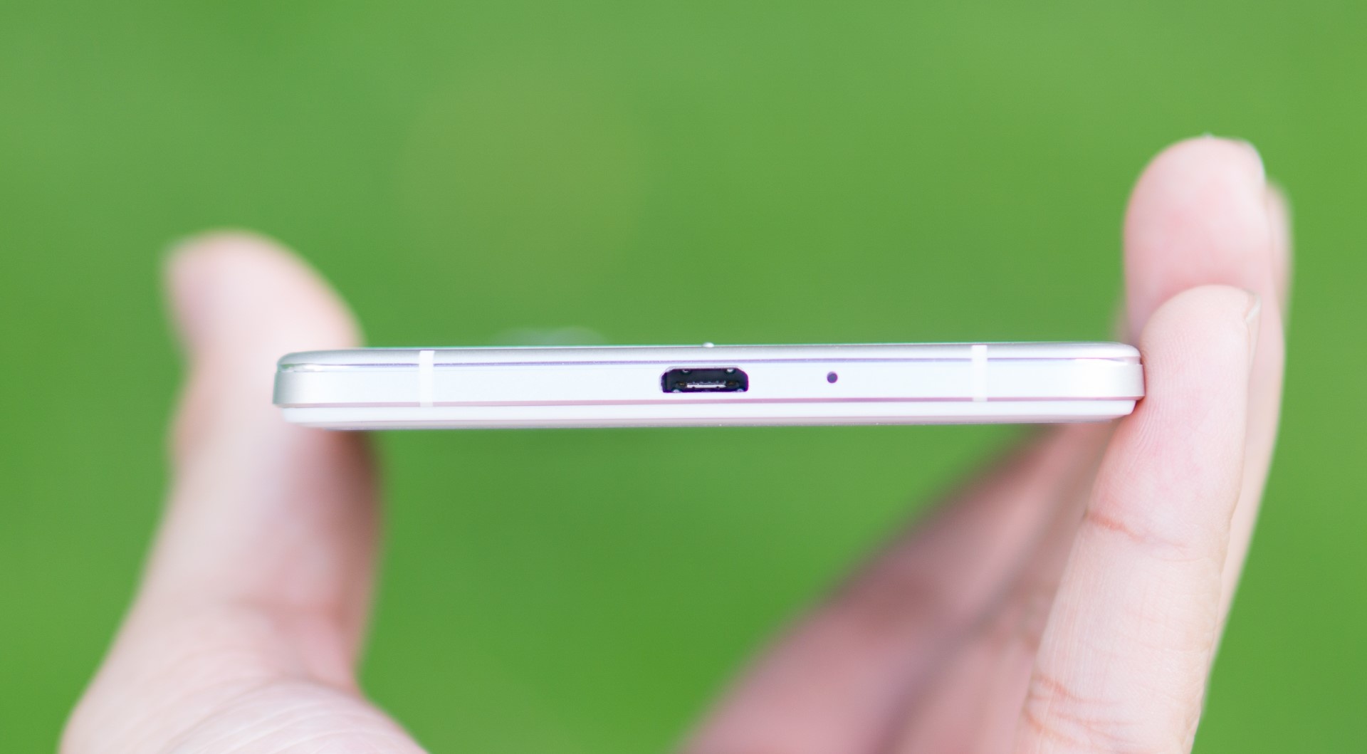 Cạnh dưới cũng có hai dải nhựa, cổng microUSB và mic thu âm. 