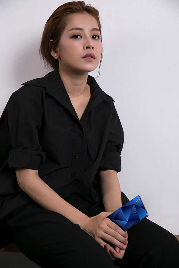 Nữ diễn viên dùng chiếc smartphone màu xanh dương bắt mắt như một phụ kiện độc đáo, tạo điểm sáng cho tổng thể diện mạo.  