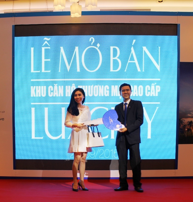 Chị Lê Nhất Diễm Hương (trái) nhận giải thưởng Vespa Sprint từ ông Vũ Quốc Việt Nam (phải) Giám đốc marketing Tập đoàn Đất Xanh.