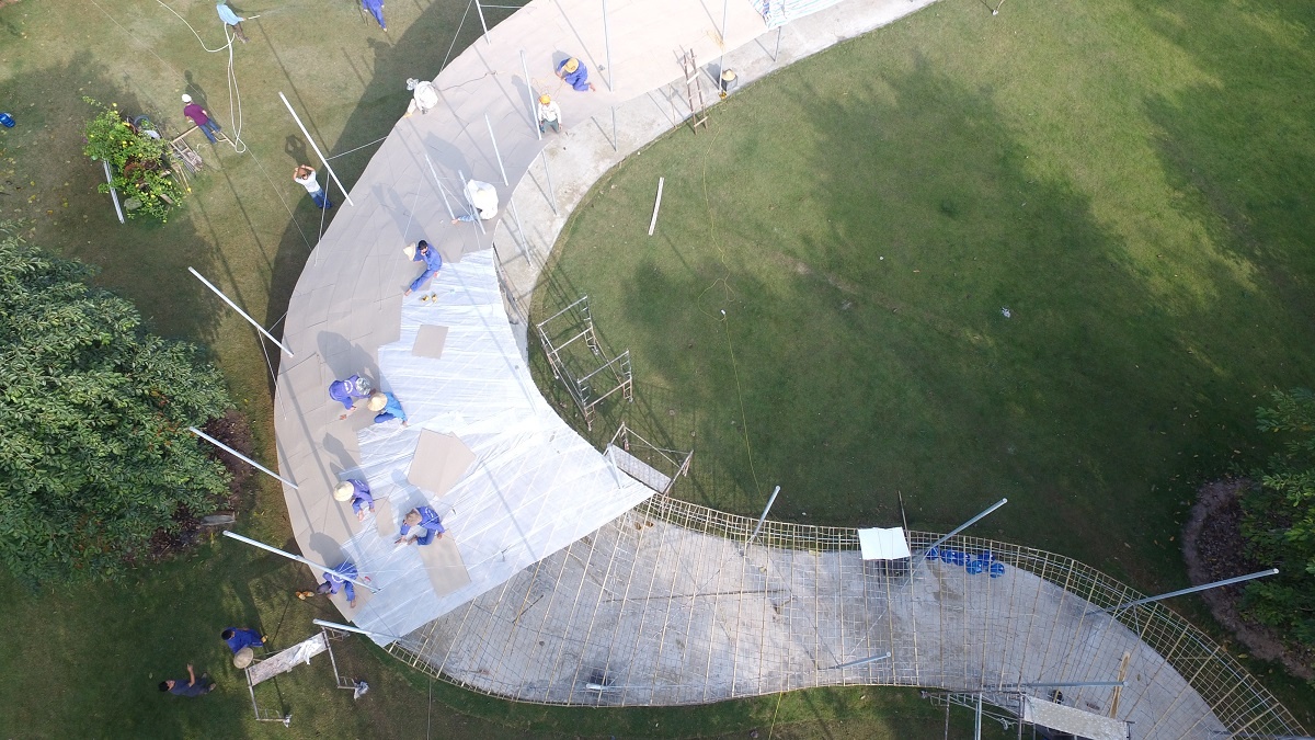  Trong hơn một tháng, 50 sinh viên tình nguyện của Đại học Mỹ thuật Công nghiệp đã tham gia công đoạn bồi giấy. Đầu tiên, họ xé những tờ giấy thật nhỏ rồi dán các lớp chồng lên nhau bằng một loại hồ đặc biệt; sau mỗi lần bồi, phải đợi hồ khô đi mới bồi lớp tiếp theo. Qua 11 lần, hình dáng phần mái mới được hoàn thiện.