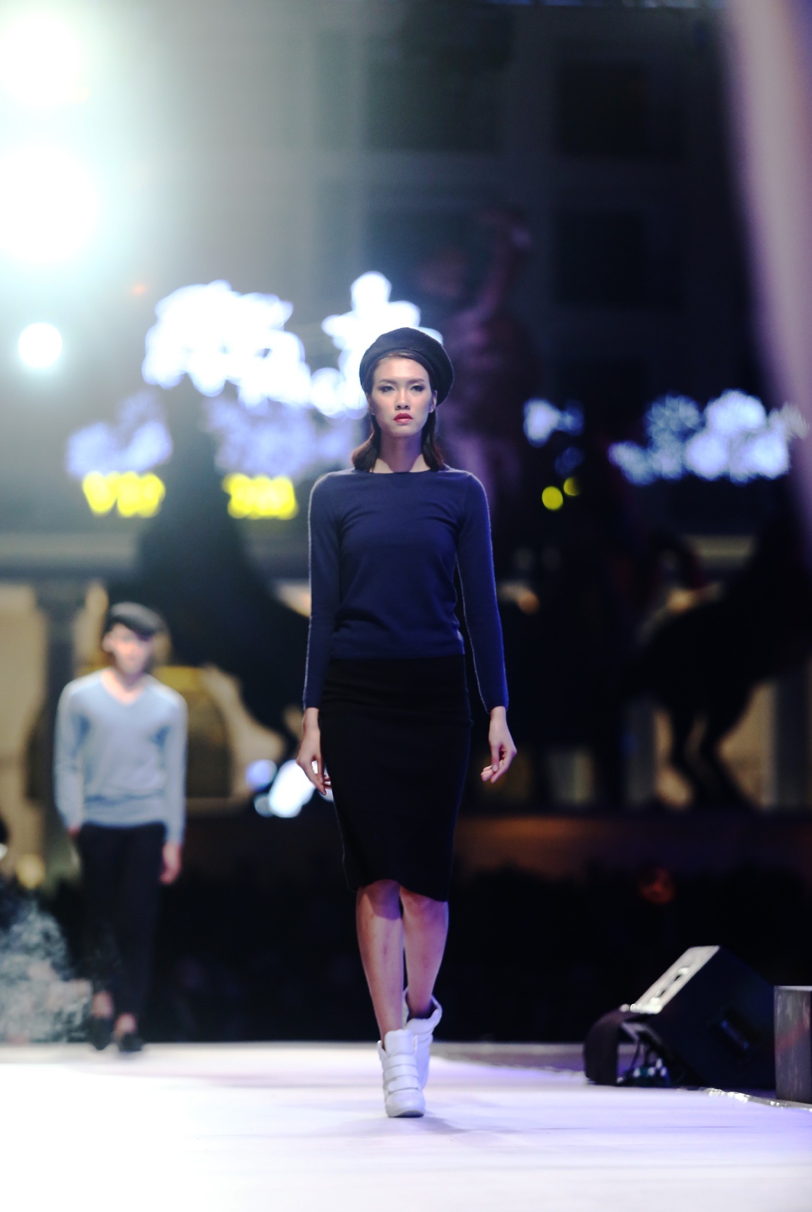 Nguyễn Oanh lạnh lùng bí hiểm trong trang phục chân váy bút chì và áo cashmere đen cổ thuyền. Set đồ này làm nổi bật bờ vai thon và chiếc cổ cao quyến rũ của cô.