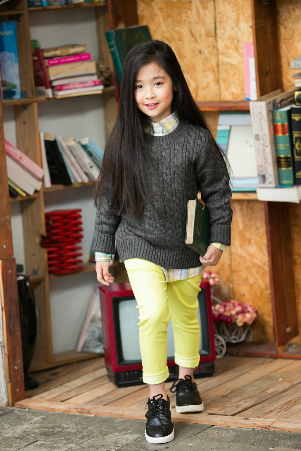 Người mẫu nhí có mái tóc dài đen mượt và gương mặt xinh xắn, ăn ảnh.