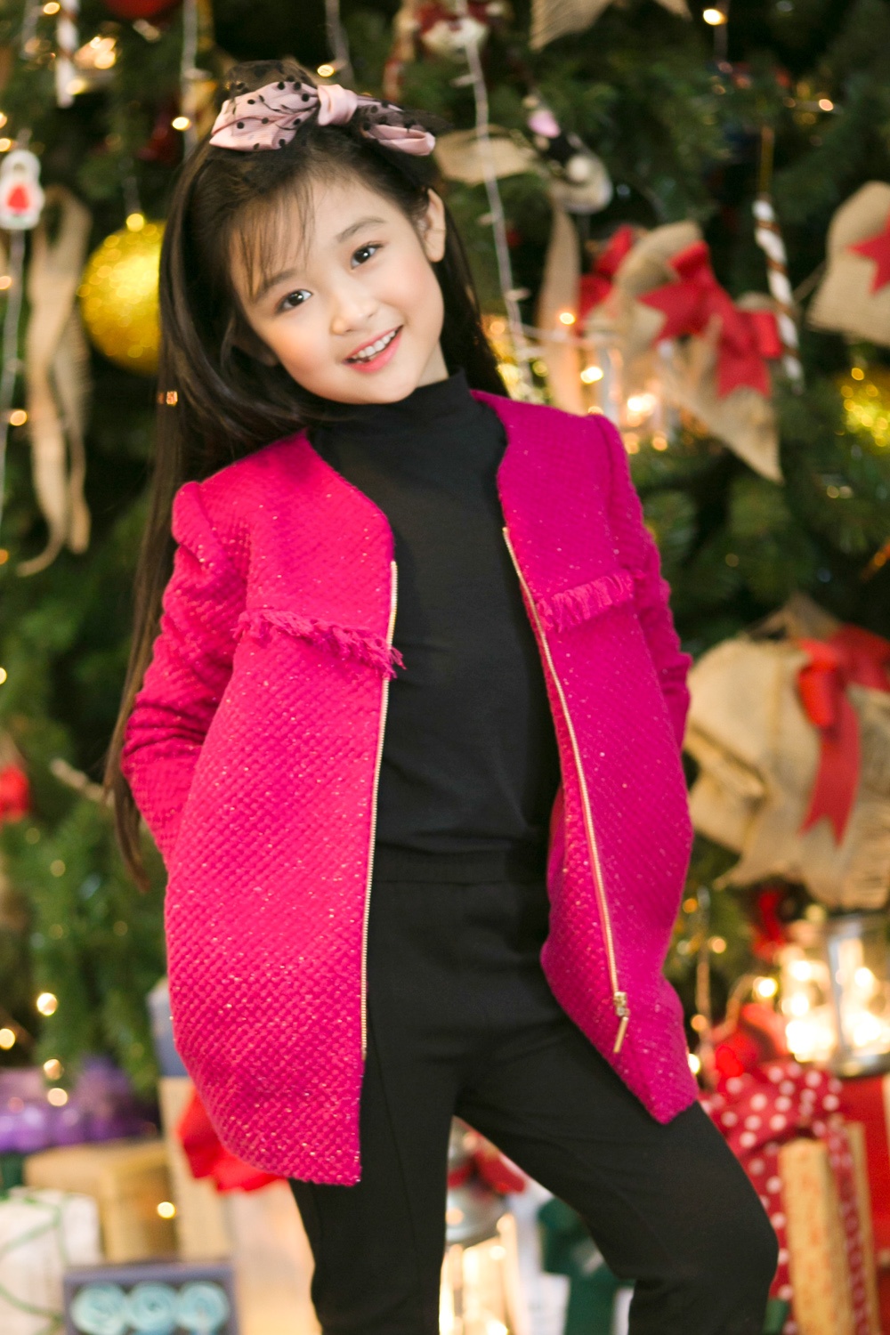Bộ trang phục “cây đen” trở nên trẻ trung hơn nhờ áo khoác màu hồng nổi bật và chiếc băng đô điệu đà.