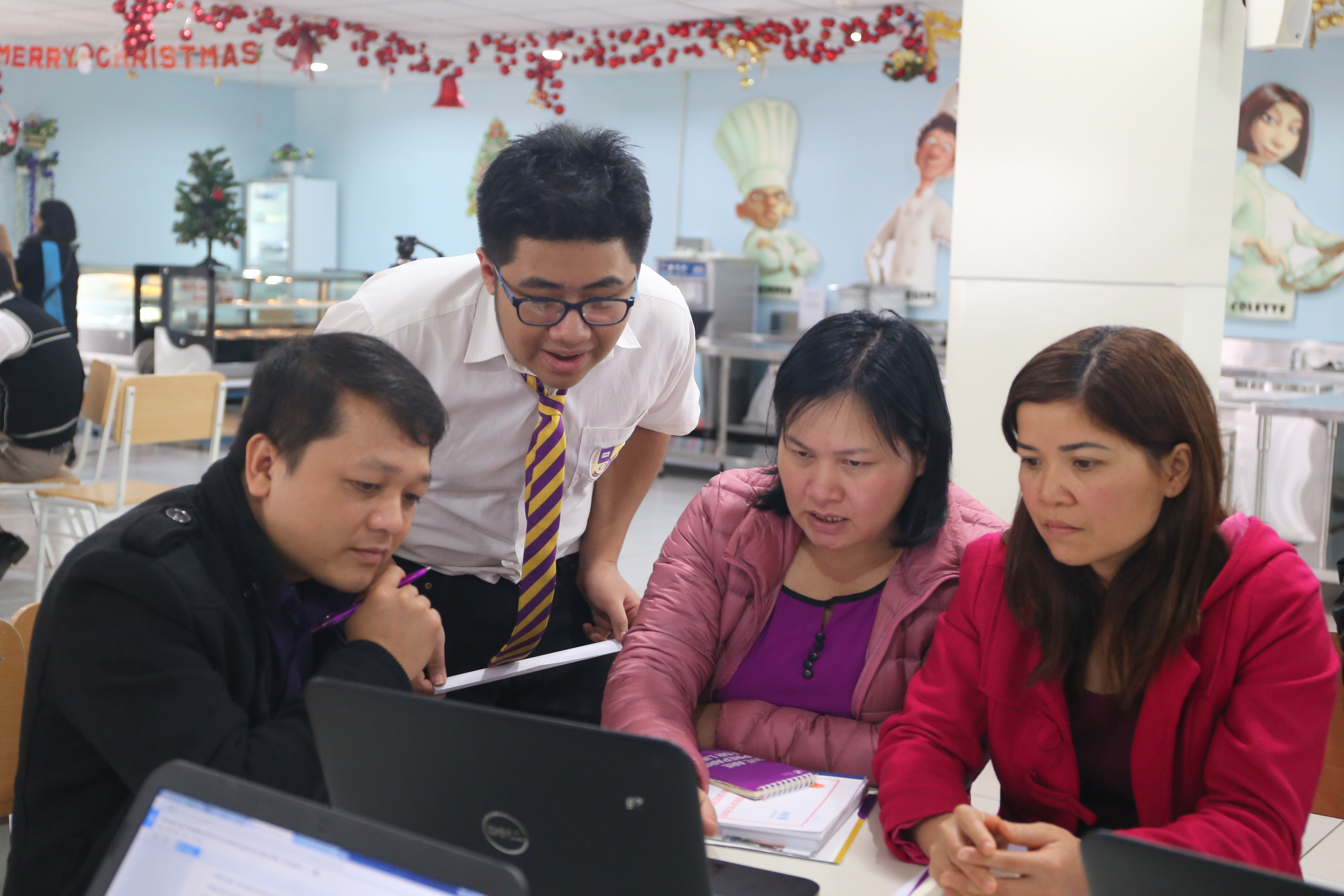 Ảnh: Cán bộ giáo dục từ nhiều đơn vị cùng thực hành trên máy tính với học sinh trường Olympia.