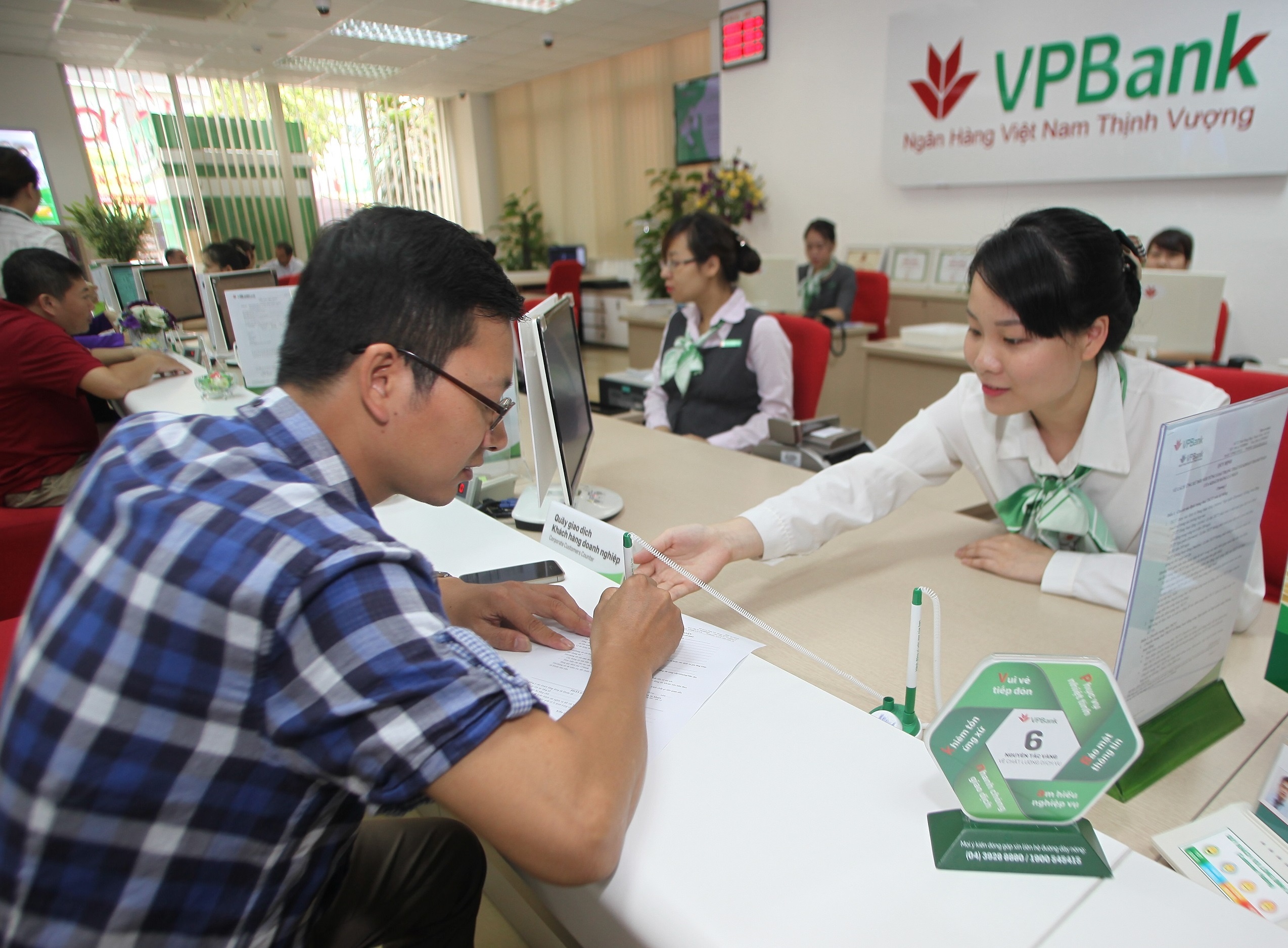 Can Tet, giao dich vien ngan hang ban biu don khach gui tien hinh anh