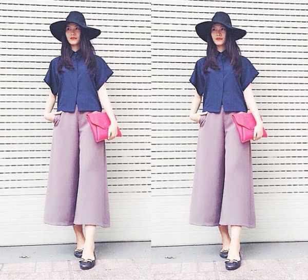 Hoa hậu Thùy Dung kết hợp quần culottes với áo sơ mi kín đáo tạo nên vẻ đẹp thanh lịch. Mũ rộng vành và chiếc clutch màu hồng càng giúp cô thêm phần cuốn hút.