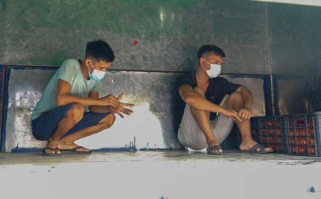 2 nguoi ngoi trong thung xe tron chot kiem tra Covid-19 anh 1