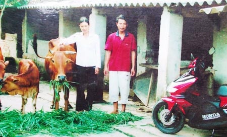 Hai vợ chồng ông Việt bên đàn bò và chiếc xe ông mua tặng vợ.