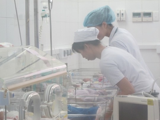 Các điều dưỡng đang chăm sóc bé trai, con sản phụ đẻ rơi.