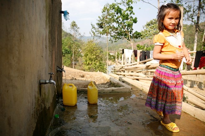Bé gái dân tộc Mông hứng nước sạch mang về nhà.