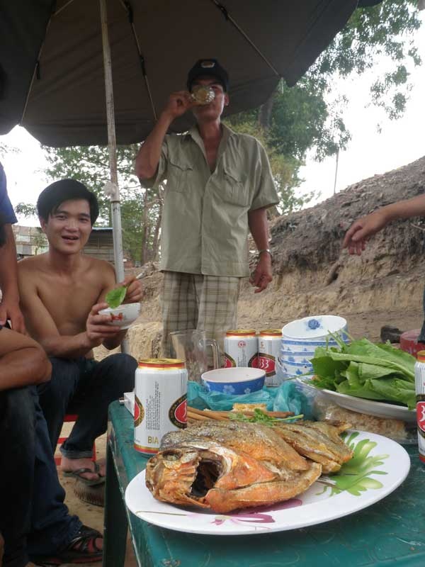 Một bàn nhậu kê bên cạnh hồ với món cá chim chiên xù vừa câu được. 